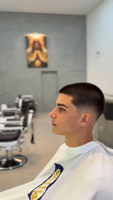 Jovem de perfil com degradê curto e contorno marcado